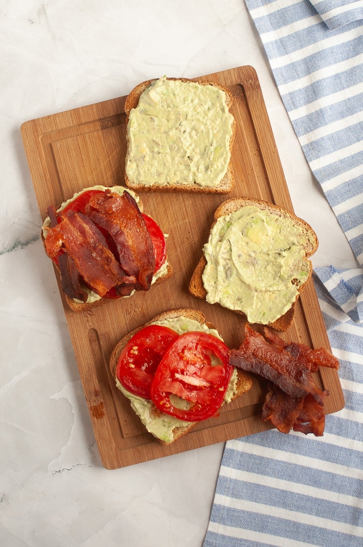 Tomato and bacon is layered onto bread spread with balsamic avocado mayo. 