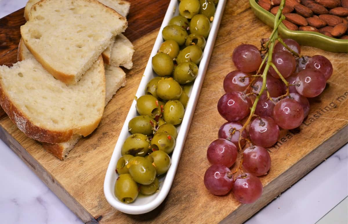 Marinated green olives, grapes and bread appetizer