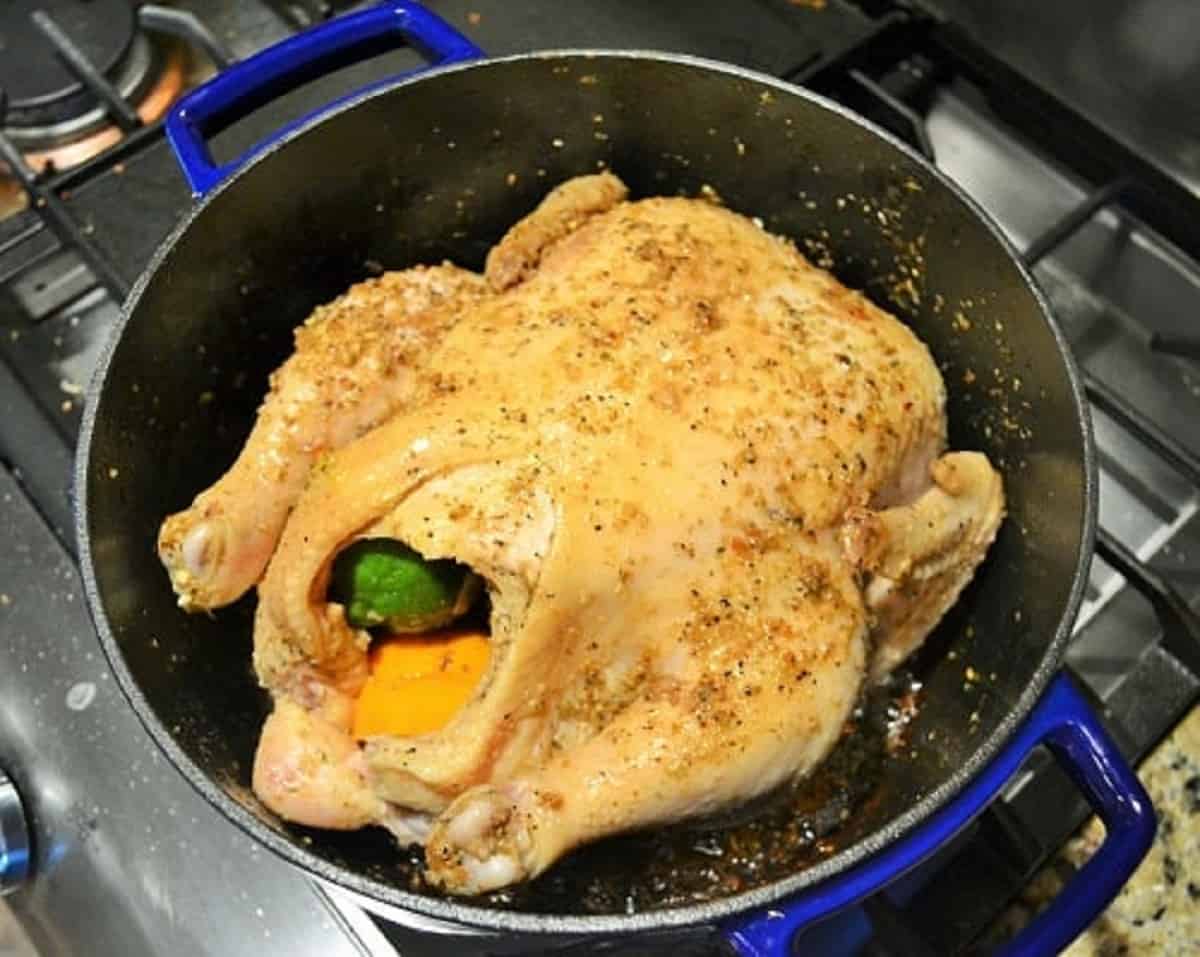 uncooked seasoned chicken in a Dutch oven