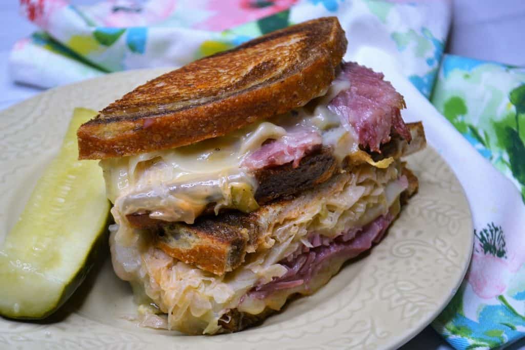 reuben sandwich with pickle on a plate