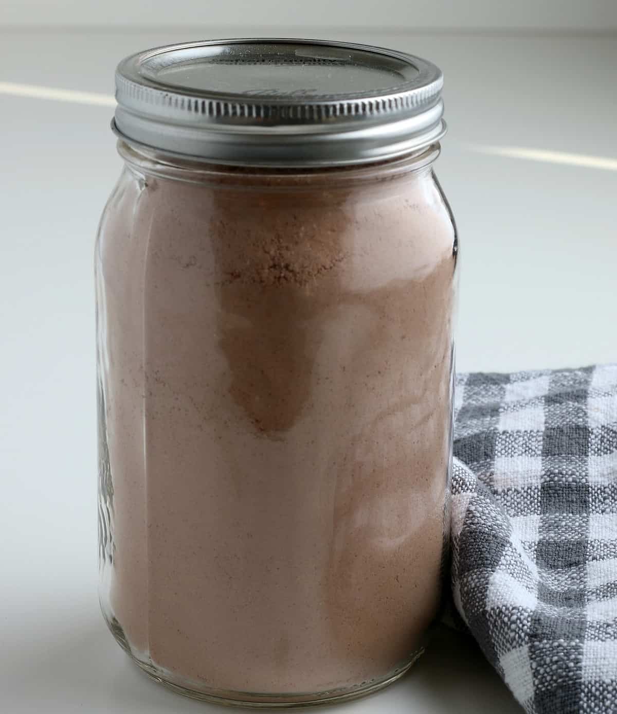 A mason jar full of cocoa mix. 