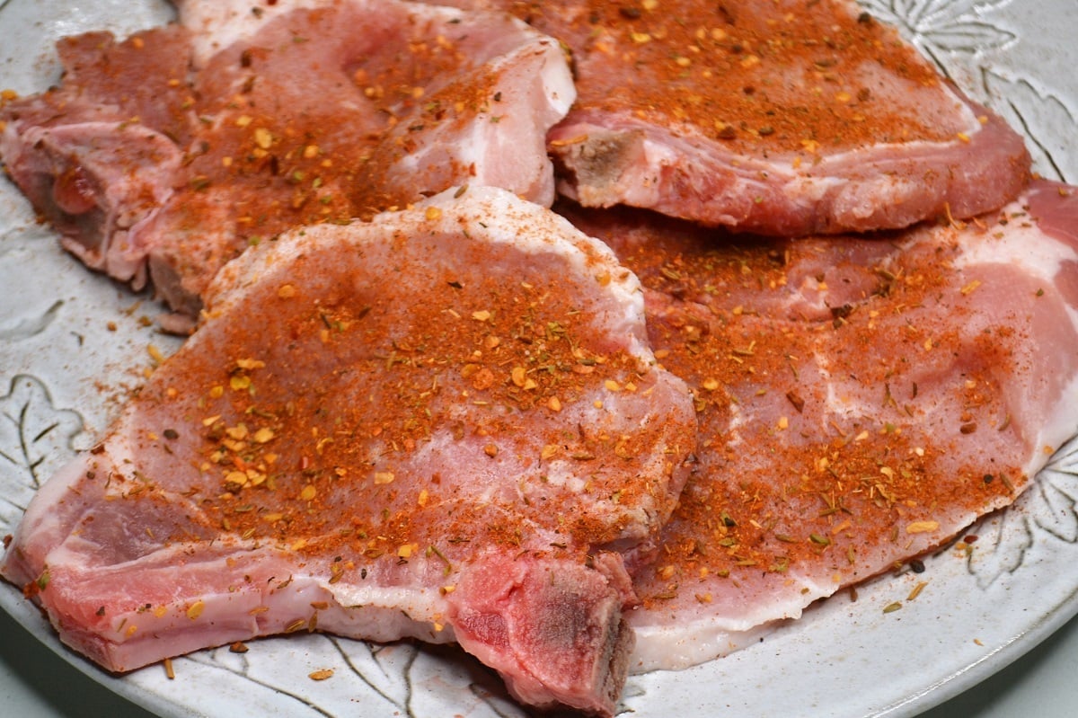 Seasoned thin cut pork chops ready to be cooked. 