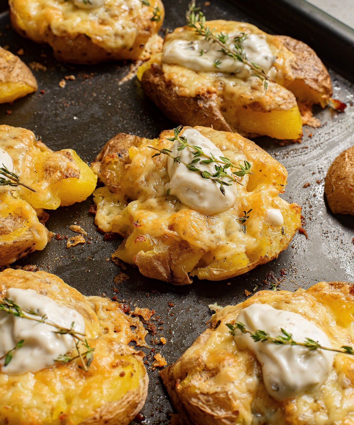 Cheesy crispy smashed potatoes on a tray. 