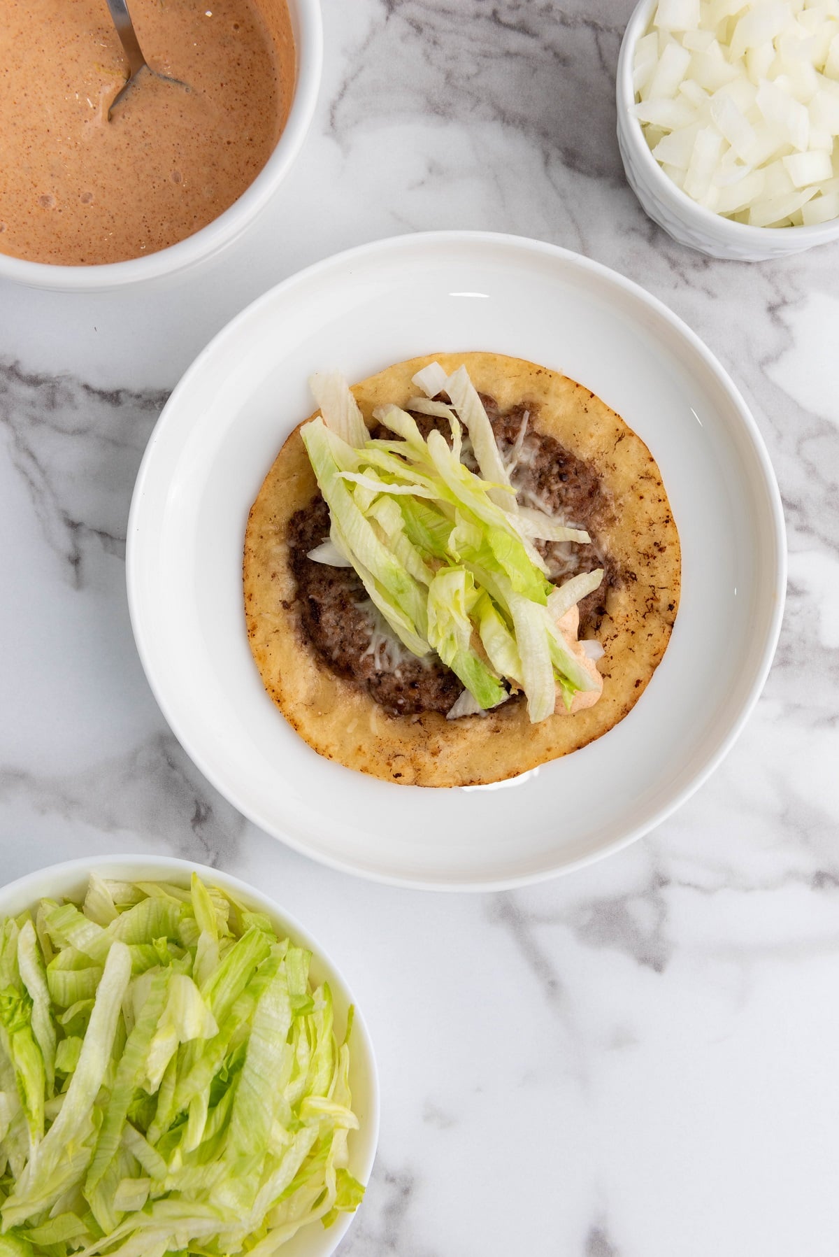 Traditional big mac toppings are added to the smash burger taco.