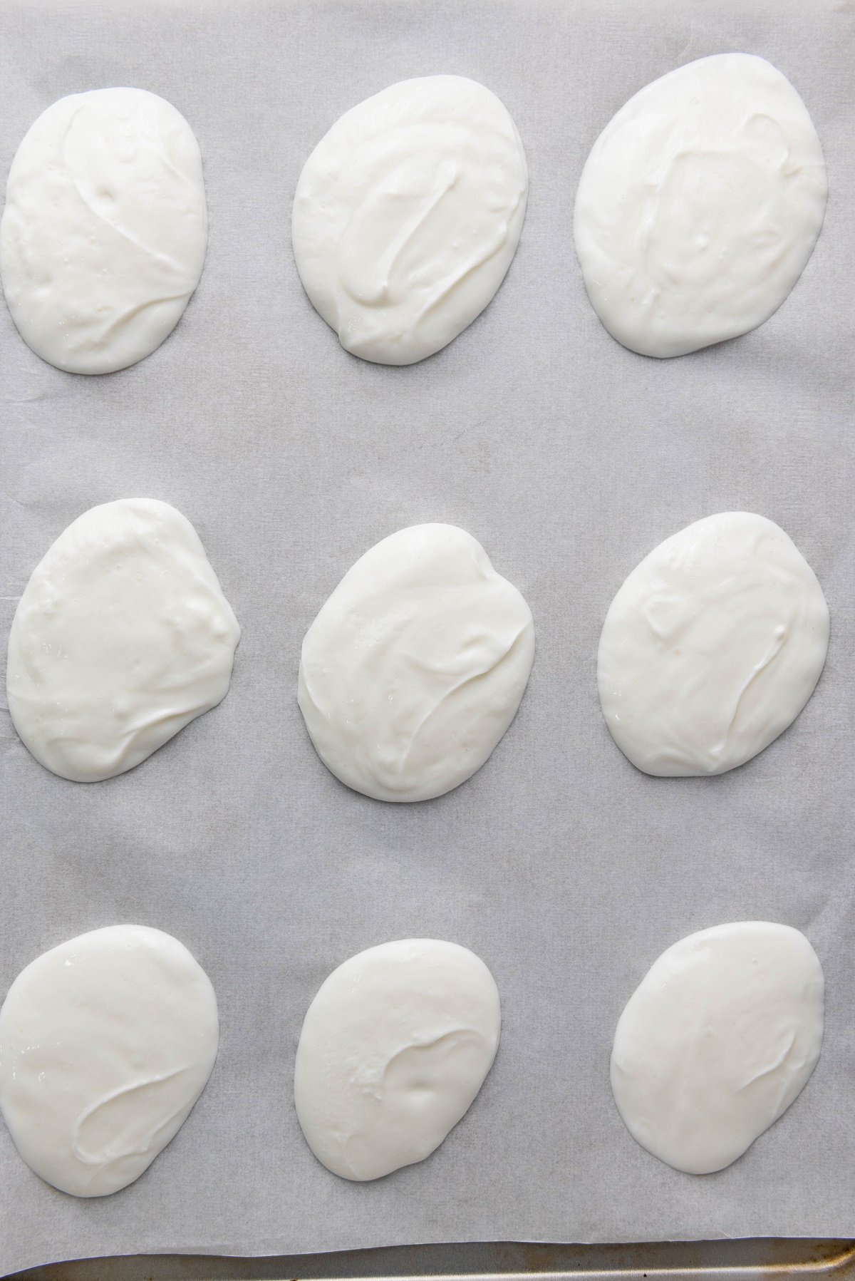 Dollops of frozen yogurt on a baking sheet. 