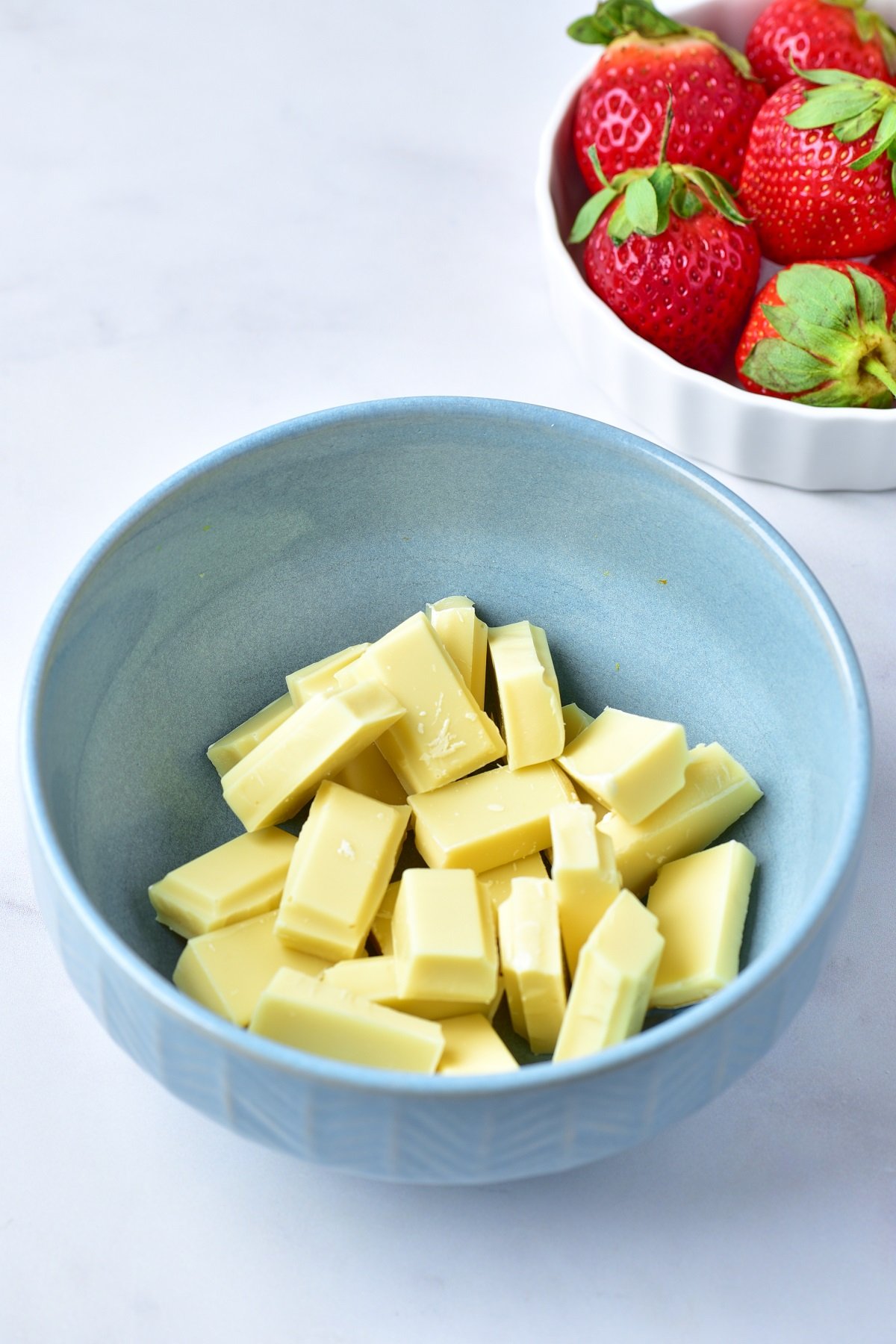 Chopped white chocolate is in a microwave safe bowl. 