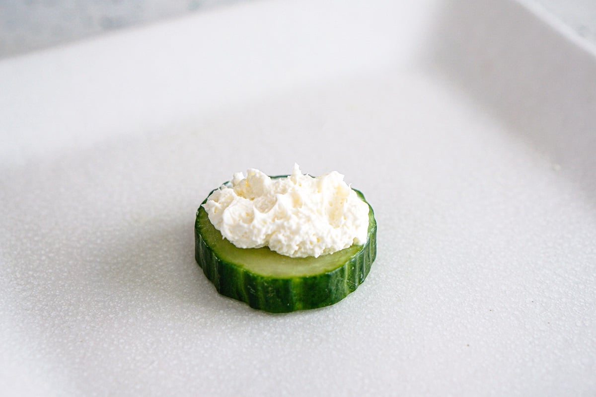 Dollop cream cheese onto cucumber rounds. 