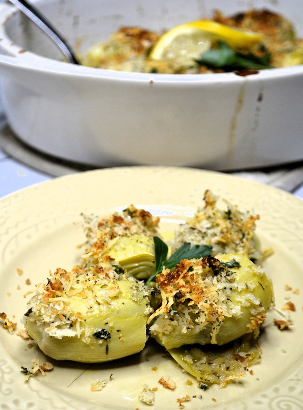 Several baked artichoke hearts are served on a plate. 