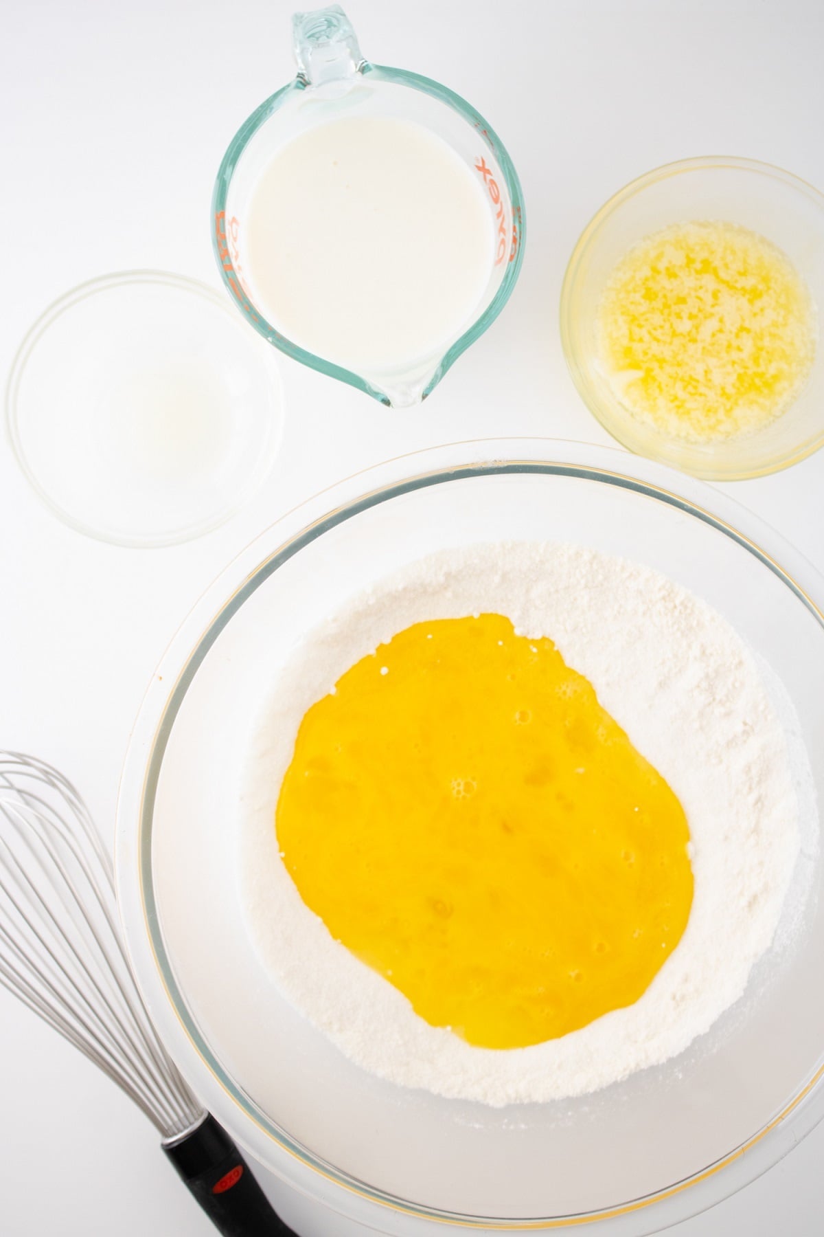 The custard filling for the pie is prepared in a glass bowl.