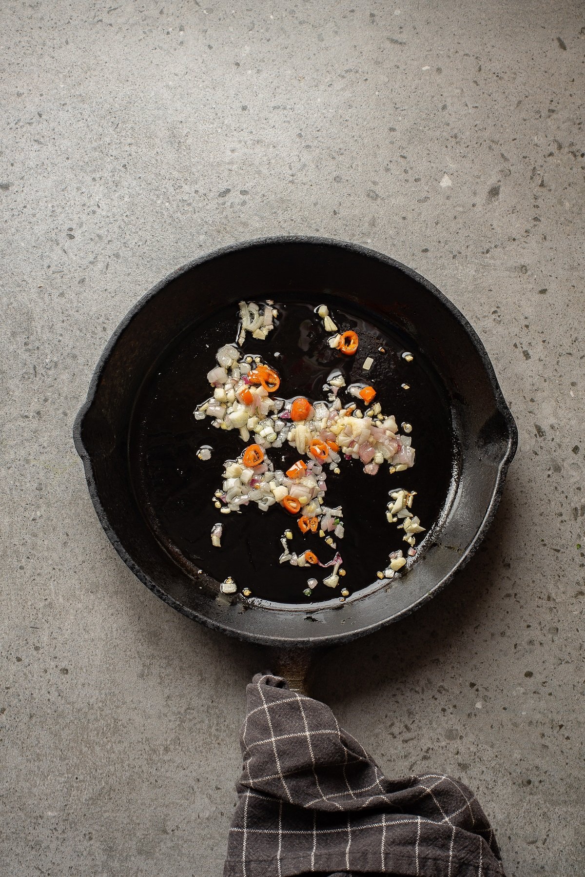 Aromatics are sauteed in a skillet. 