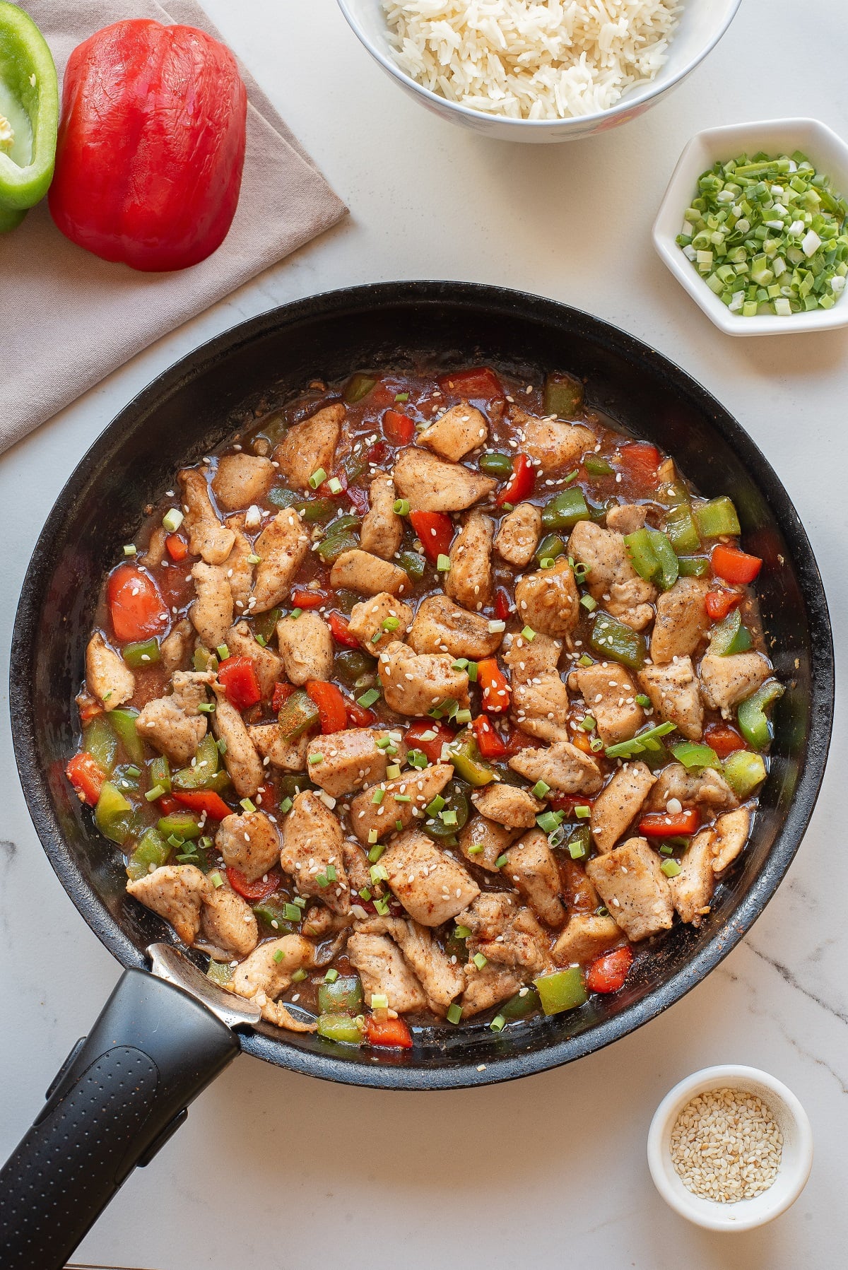 Hunan chicken garnished with sesame seeds in a skillet. 