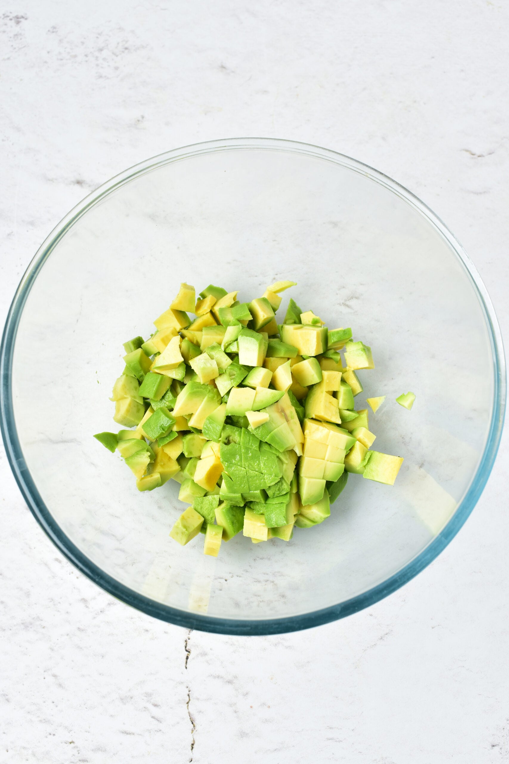 Chopped avocado is placed in a bowl. 