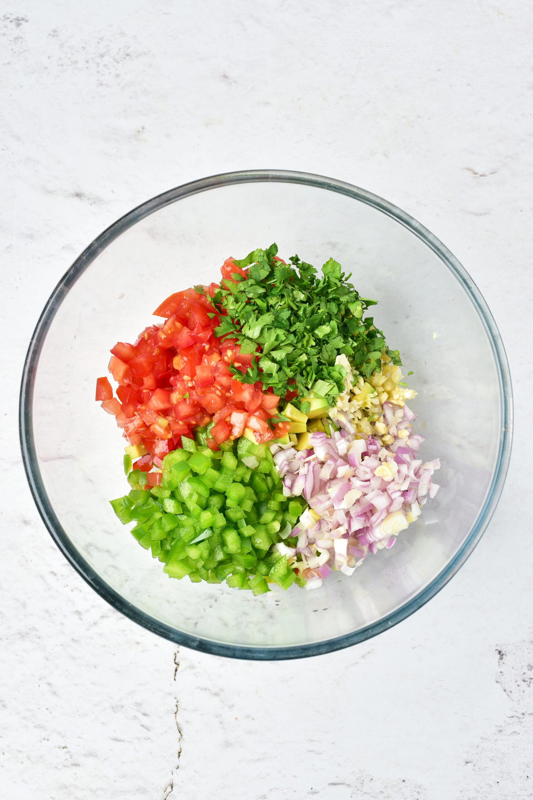 Salsa ingredients are added to a bowl. 