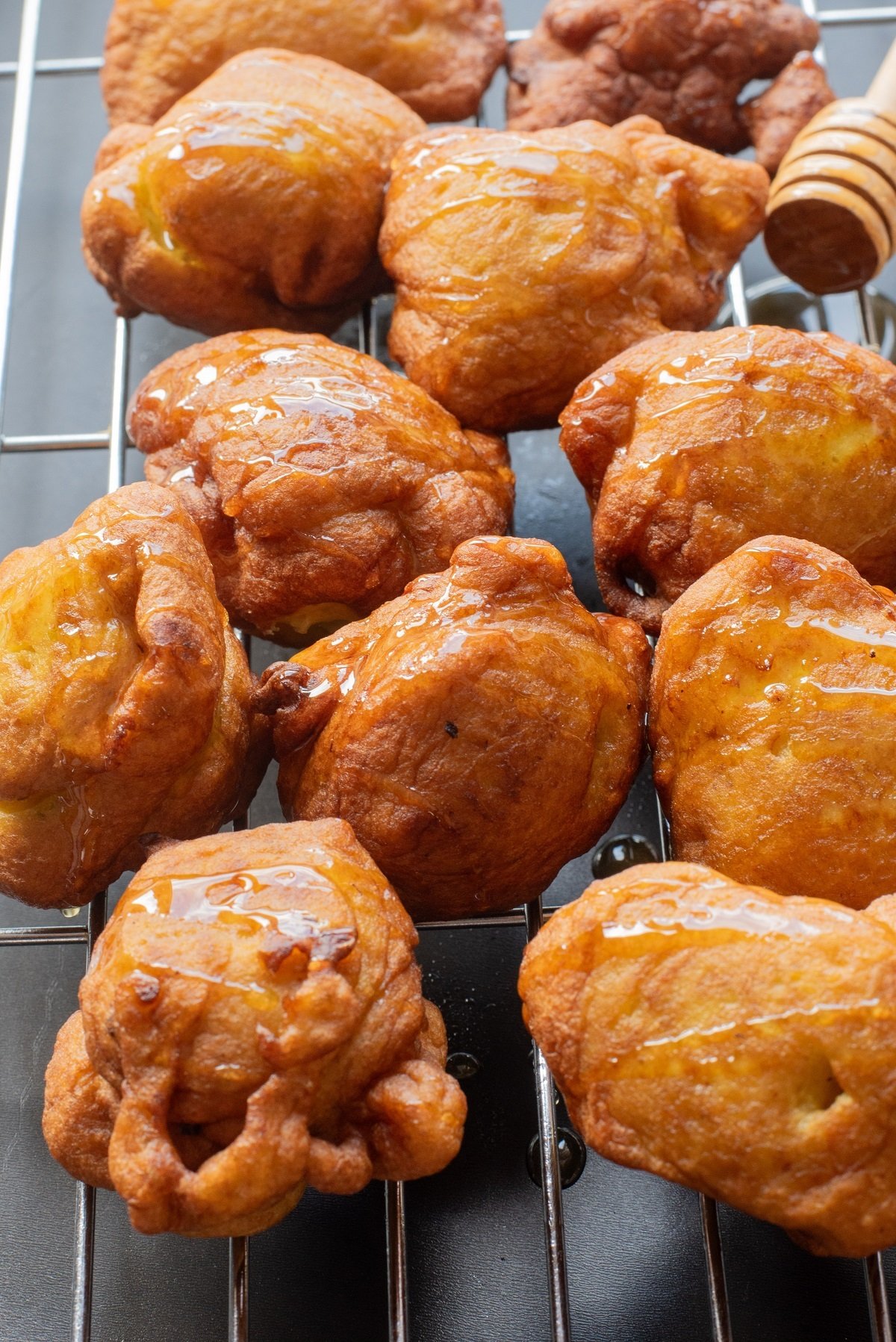 Golden pumpkin fritters on a wire rack drizzled with honey. 