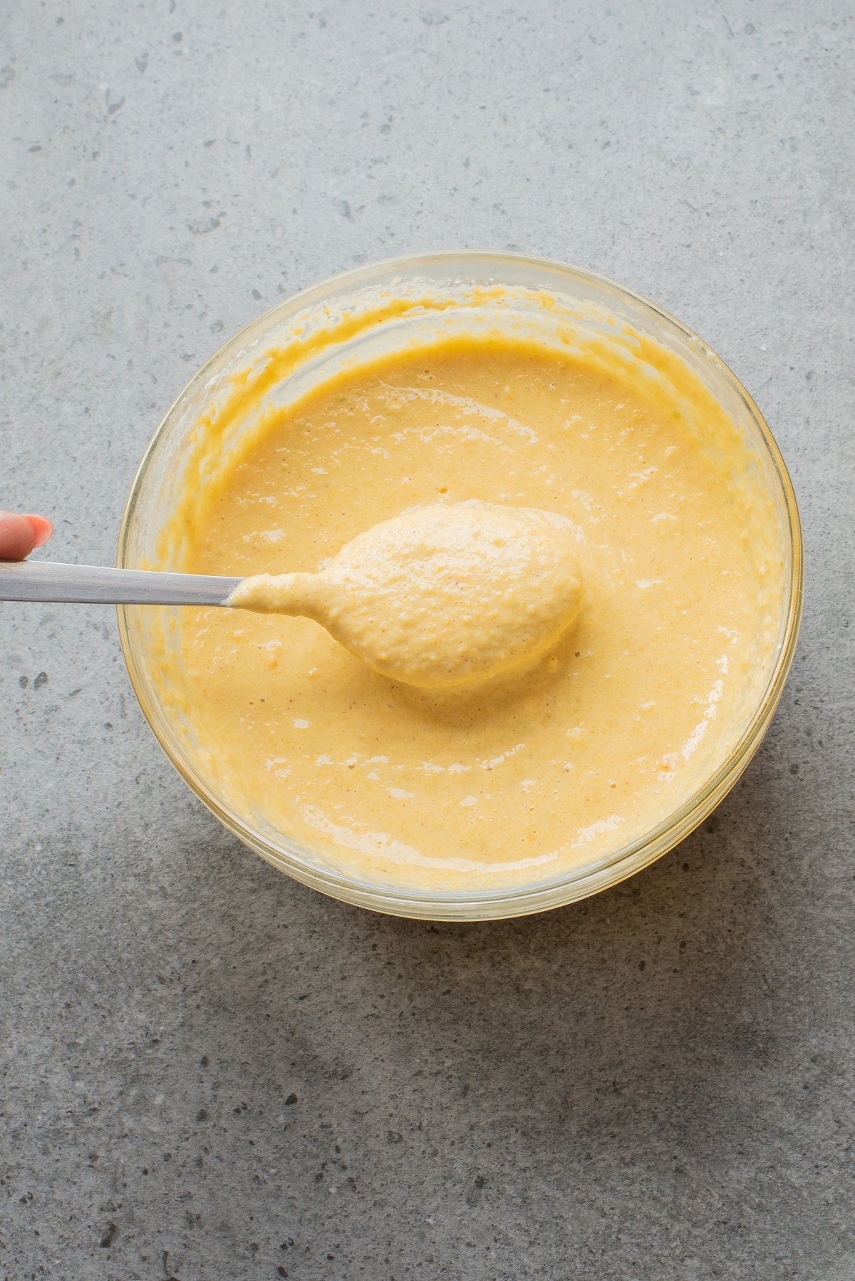 Fritter batter is prepared in a bowl and stirred until thick. 