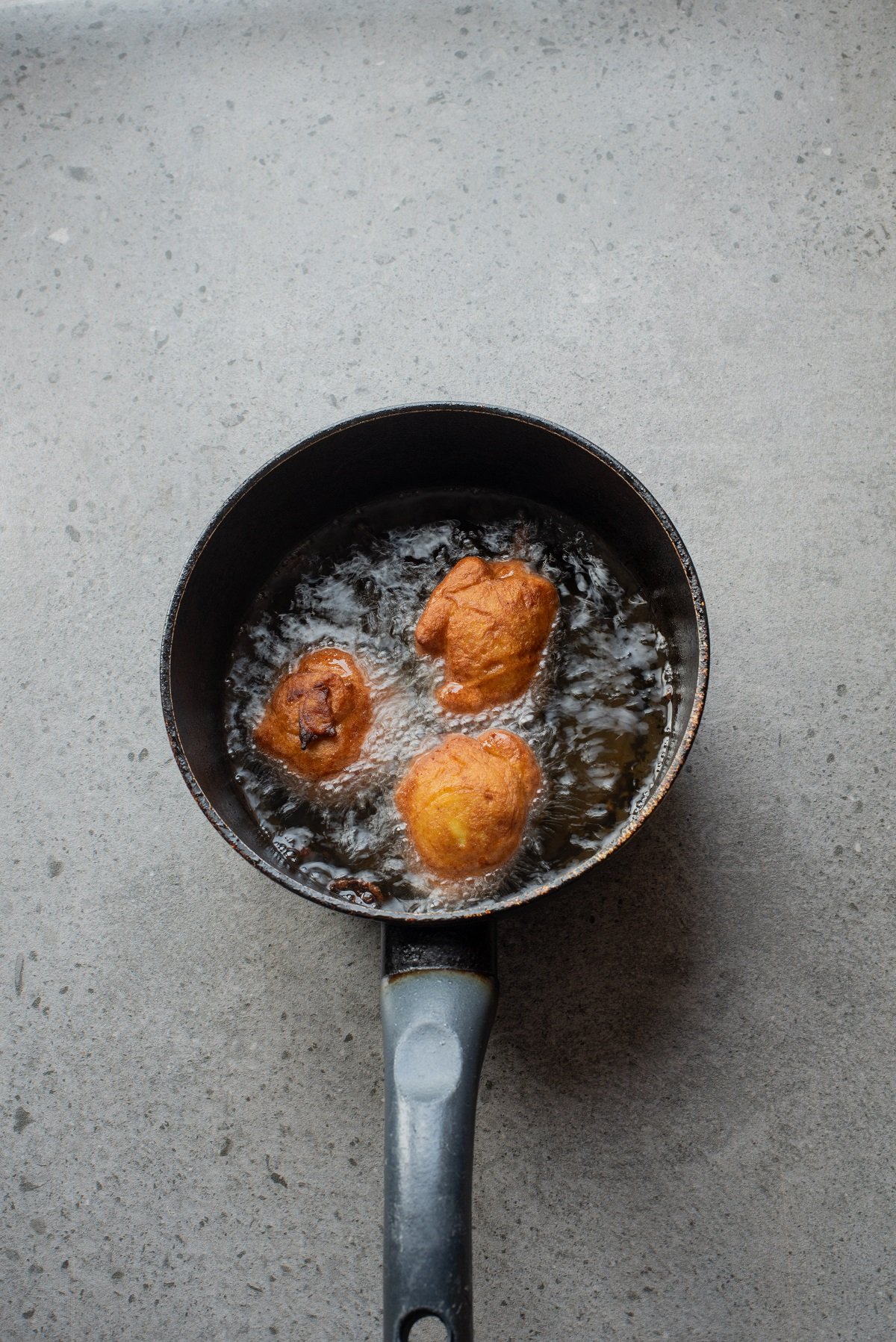 Dollops of batter are dropped into hot oil and fried until golden. 