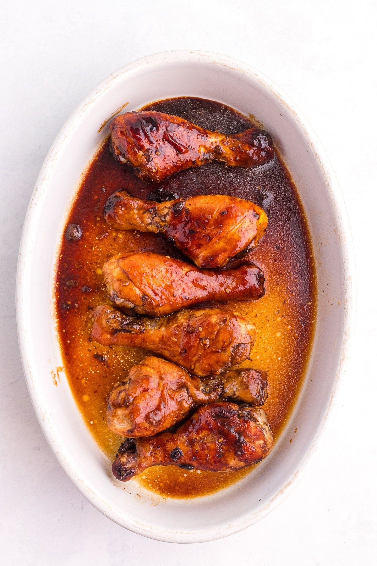 Glaze chicken legs in a baking dish. 