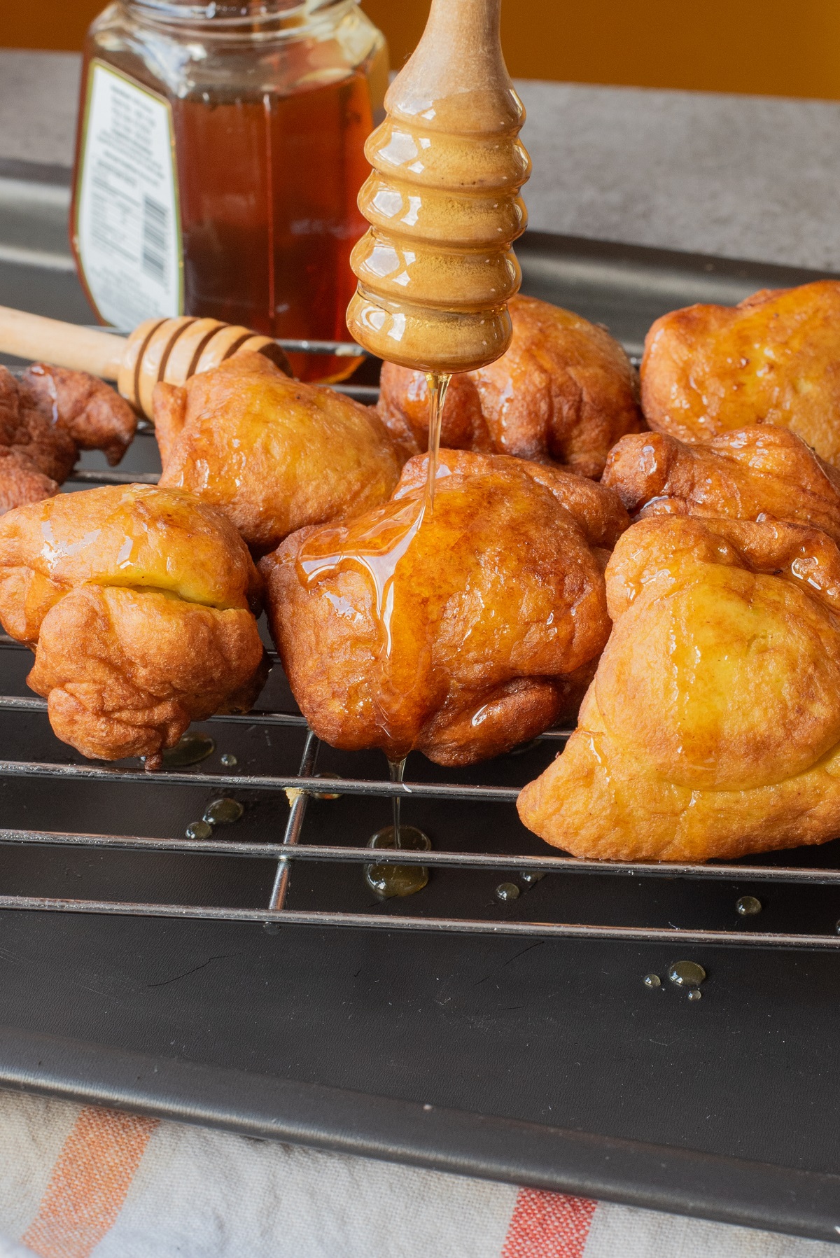 Pumpkin fritters drizzled with honey on a tray. 