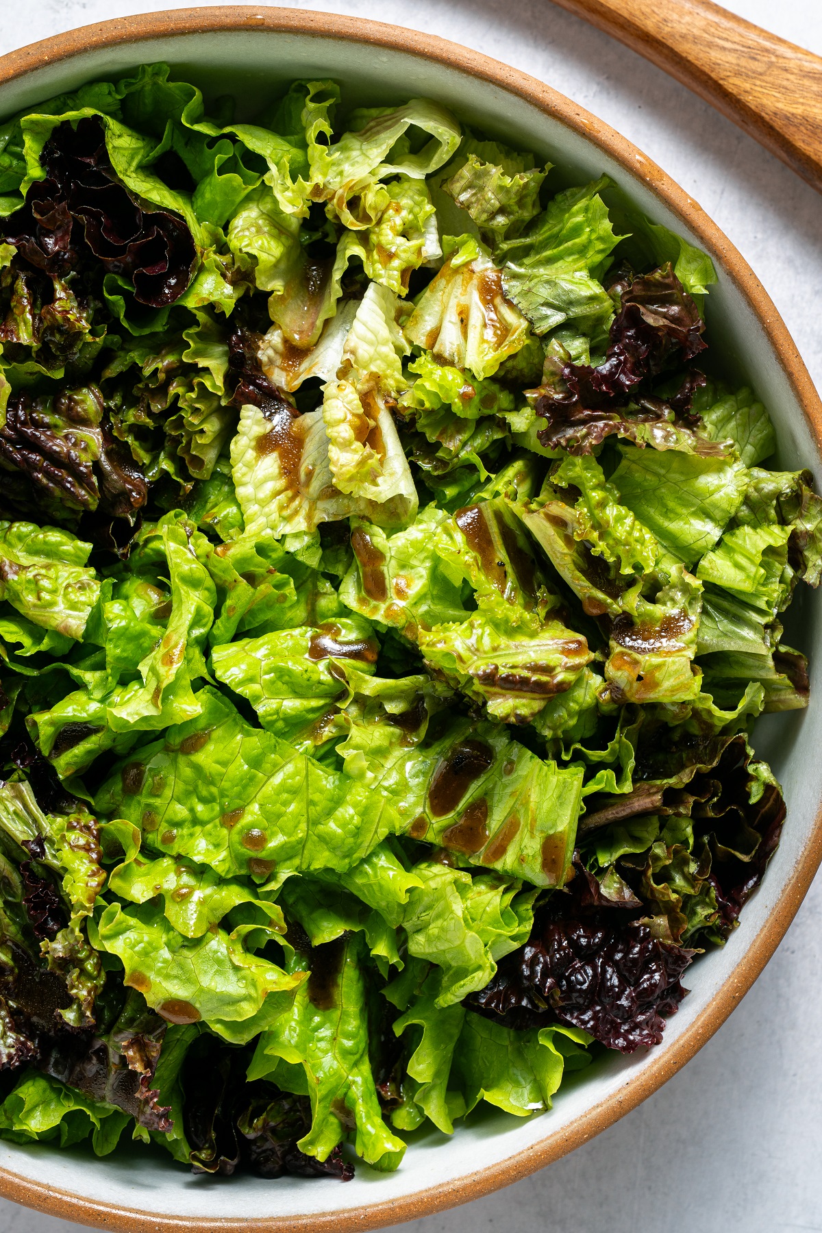 Mixed greens are topped with dressing. 