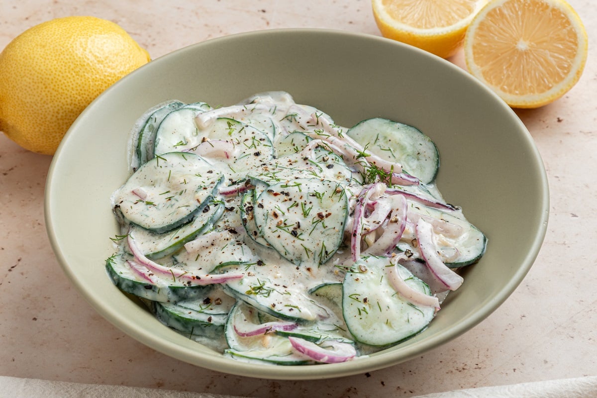 Creamy cucumber and dill salad with red onion in a bowl. 
