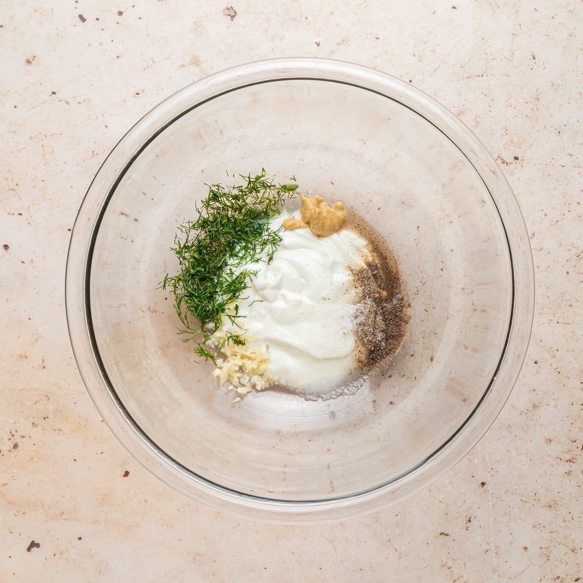 Creamy dill dressing ingredients are combined in a bowl. 