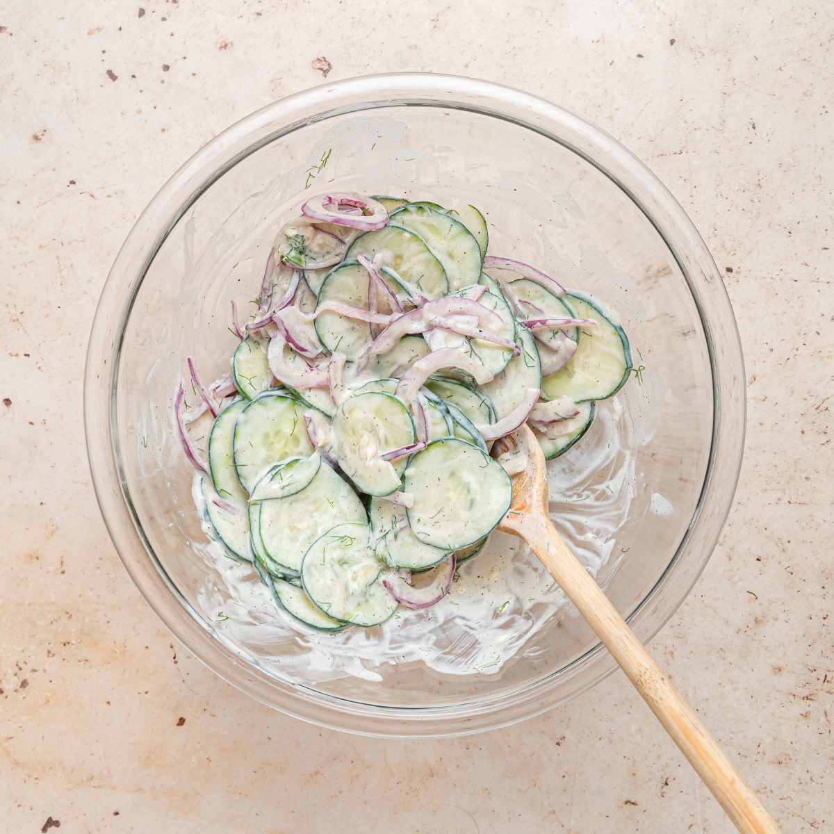 Cucumbers and onions are stirred into the dressing mixture. 