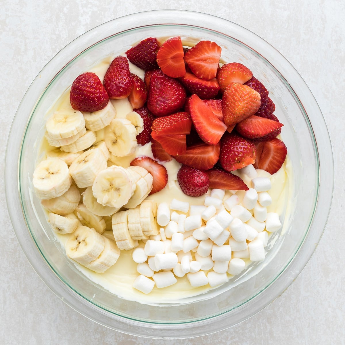 Strawberries, bananas and marshmallows are stirred into a yogurt and cream cheese mixture. 
