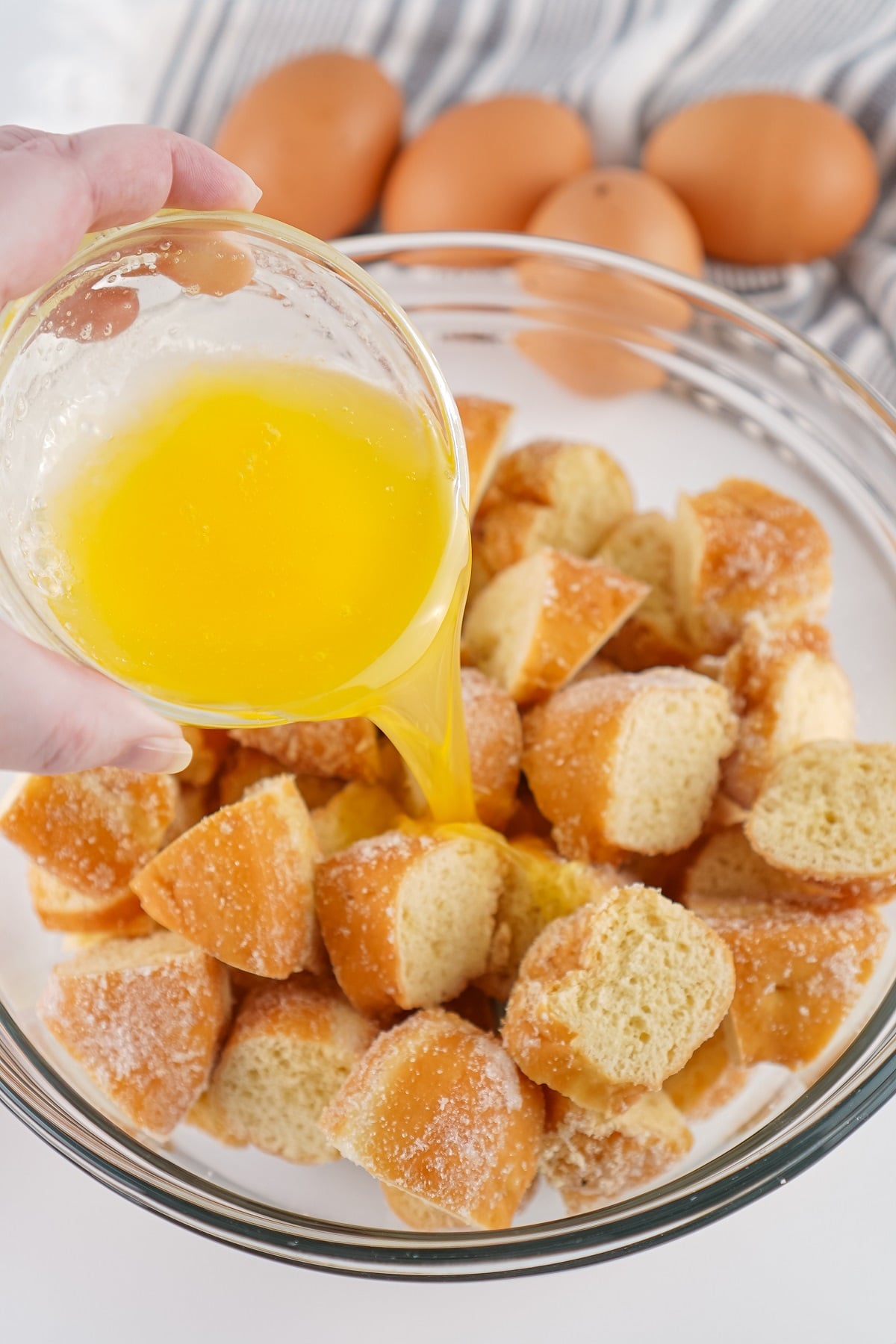 Melted butter and chopped dounuts are combined in a bowl. 