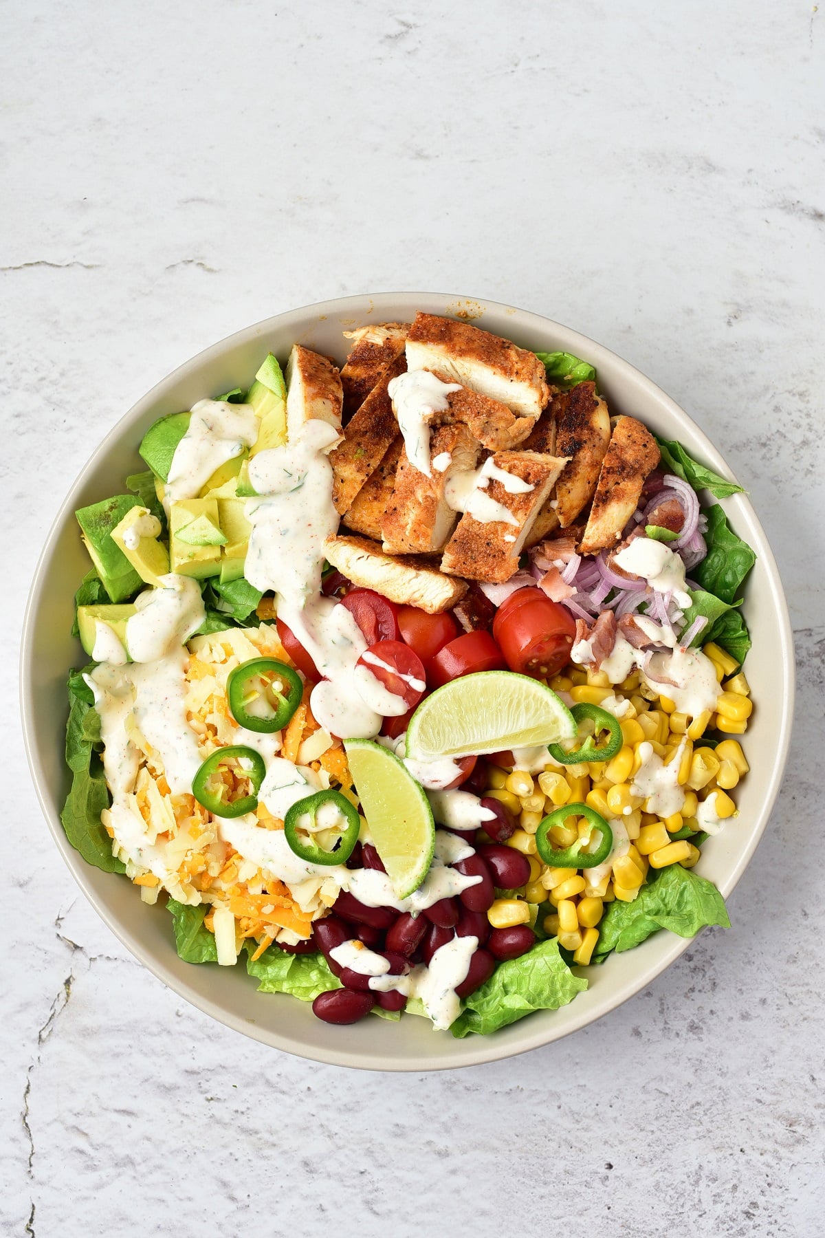 Individual servings of southwest chicken salad are prepared in a bowl.