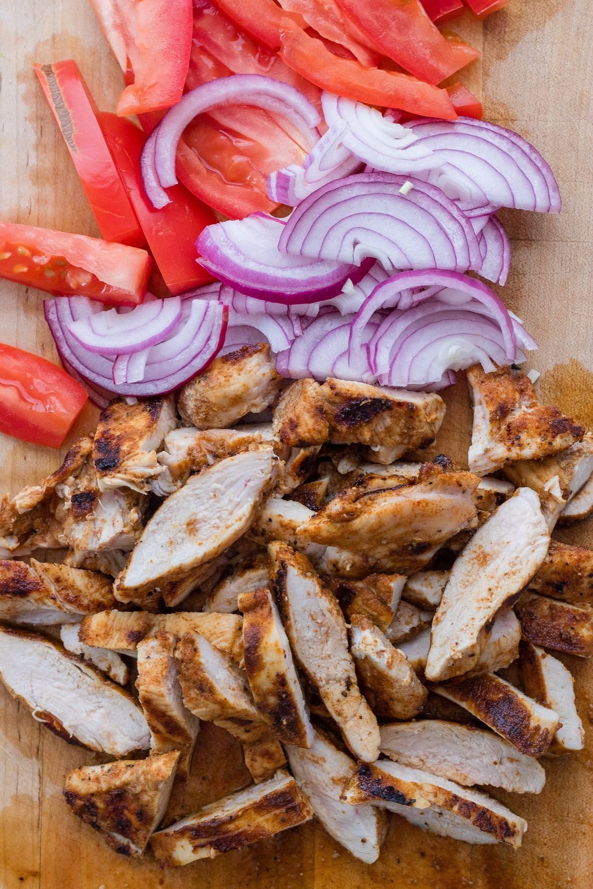 Cooked chicken and fresh veggies are sliced.