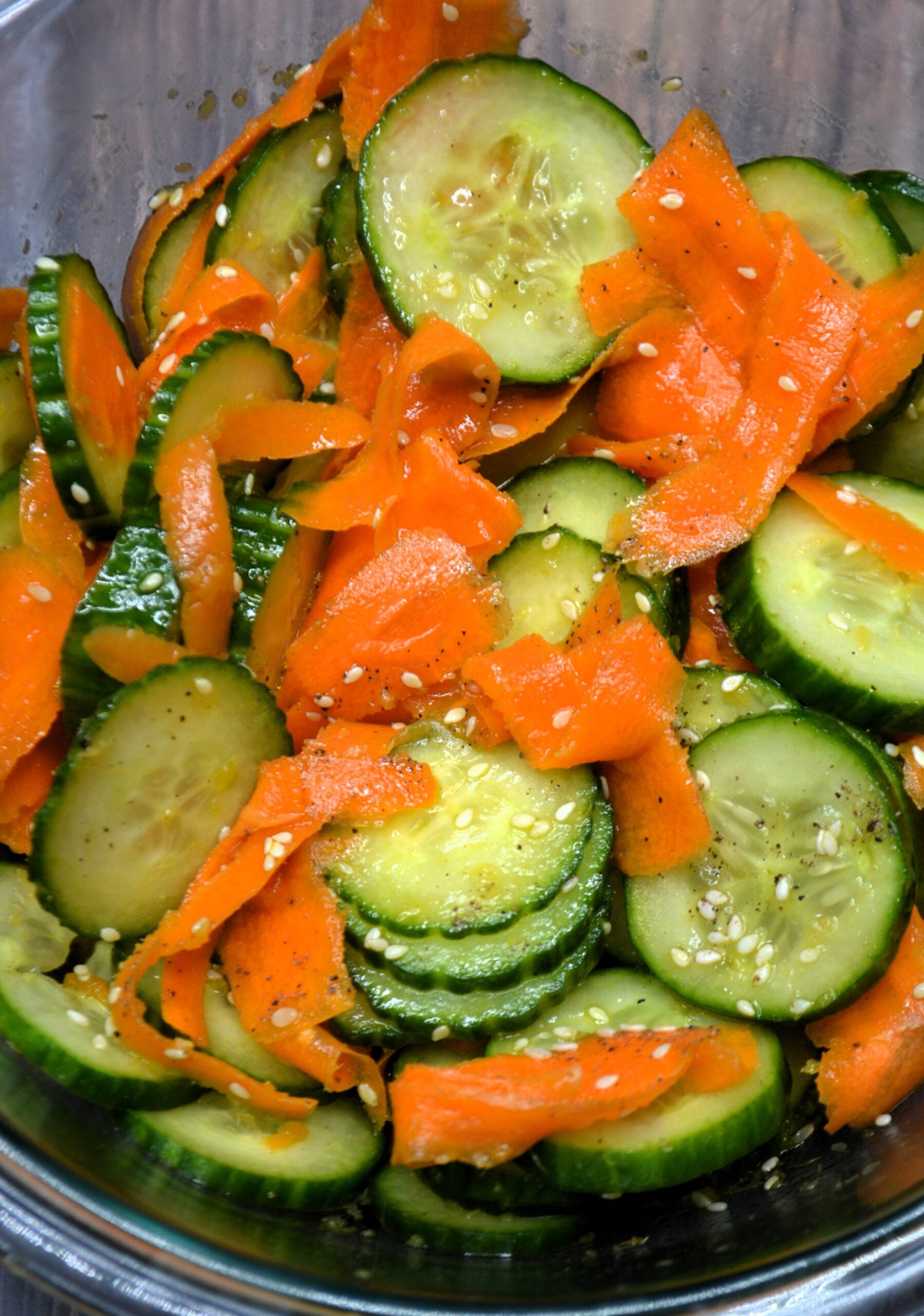 Closeup of carrot and cucumber salad topped with sesame seeds. 