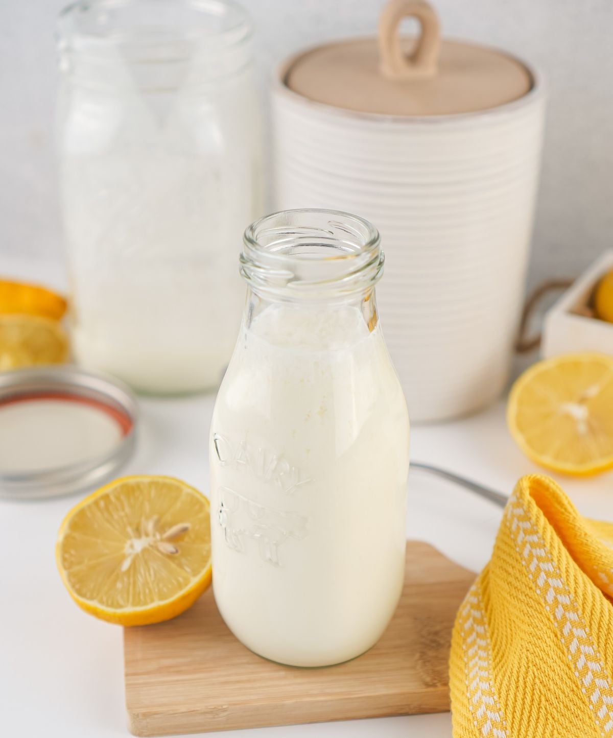 A glass jug of buttermilk substitute with a lemon beside it.