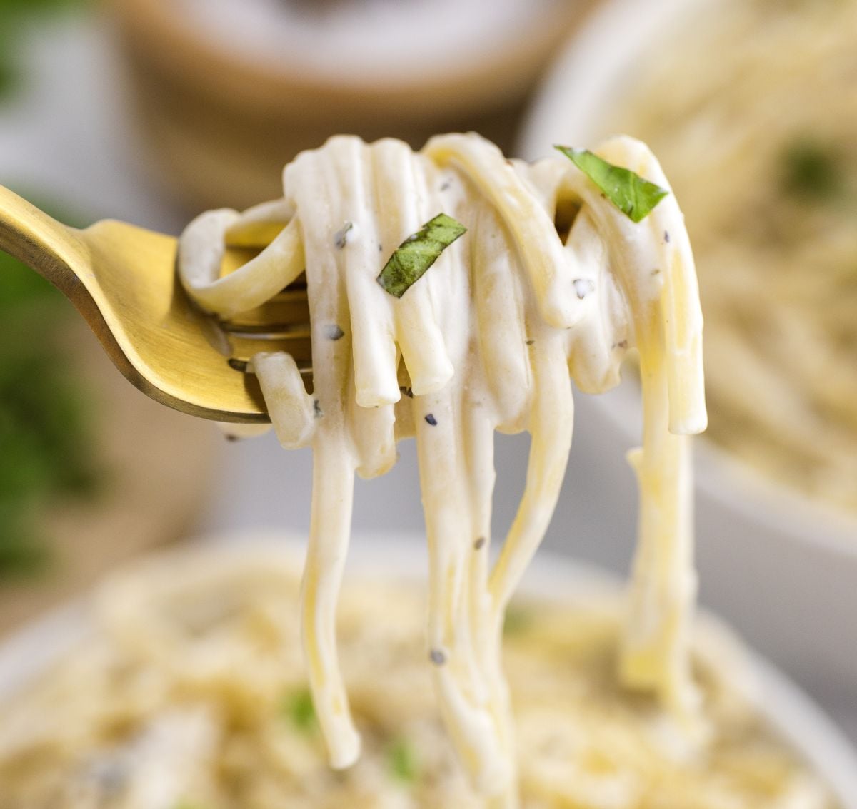 A fork lifts a serving of noodles coated with a creamy Boursin sauce. 
