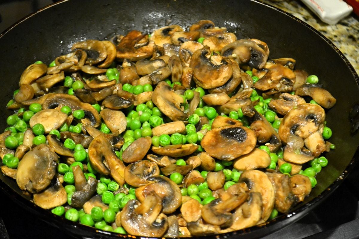 Mushrooms and peas in a skillet.