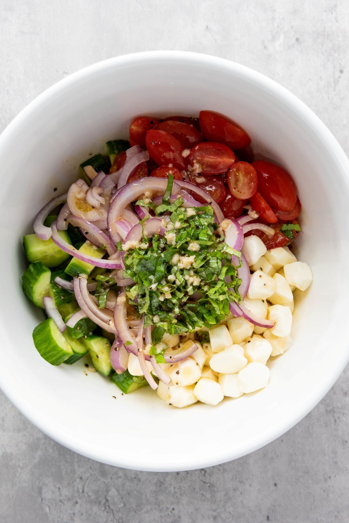 Salad ingredients are added to a bowl.